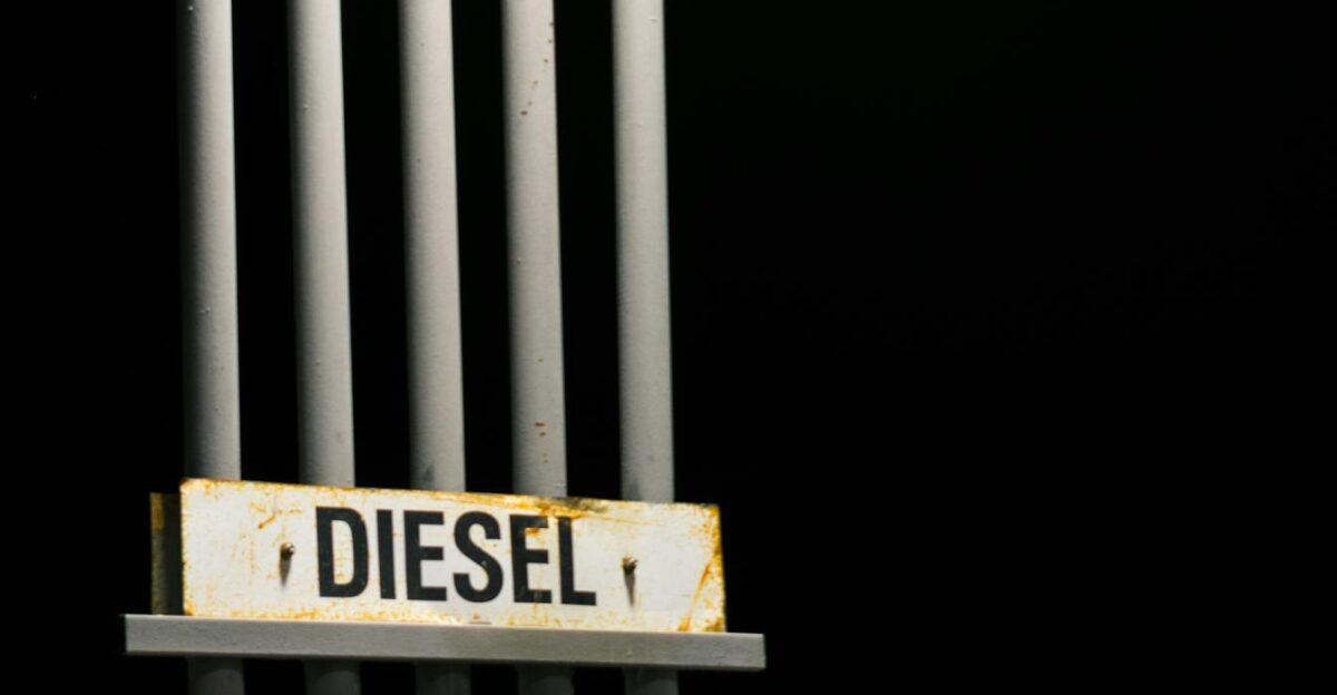 Diesel fuel sign on metal pipes against a dark black background at night