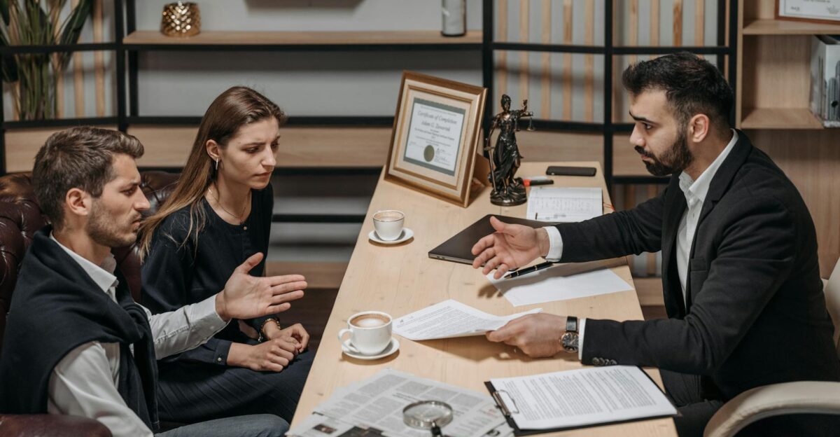 Lawyer consulting clients in an office Documents and coffee on the table