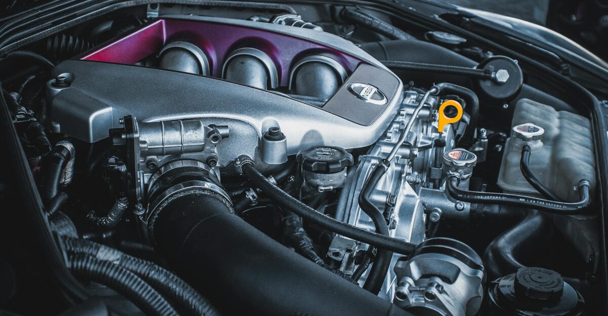 Detailed shot of a Nissan car engine bay featuring intricate engine parts and components