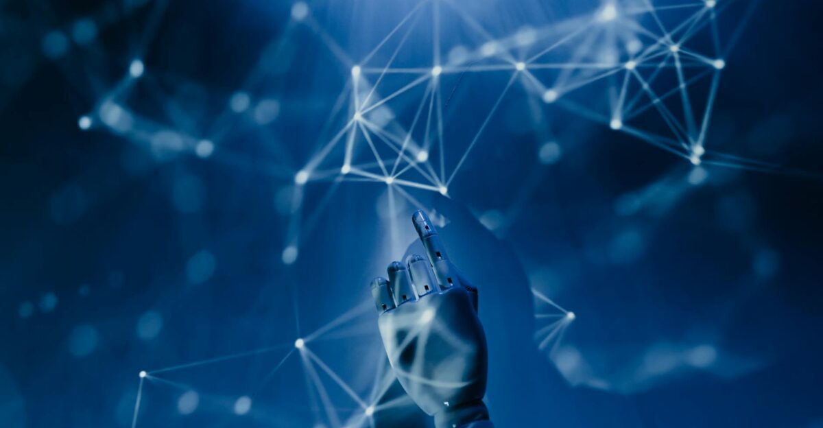 A robotic hand reaching into a digital network on a blue background symbolizing AI technology