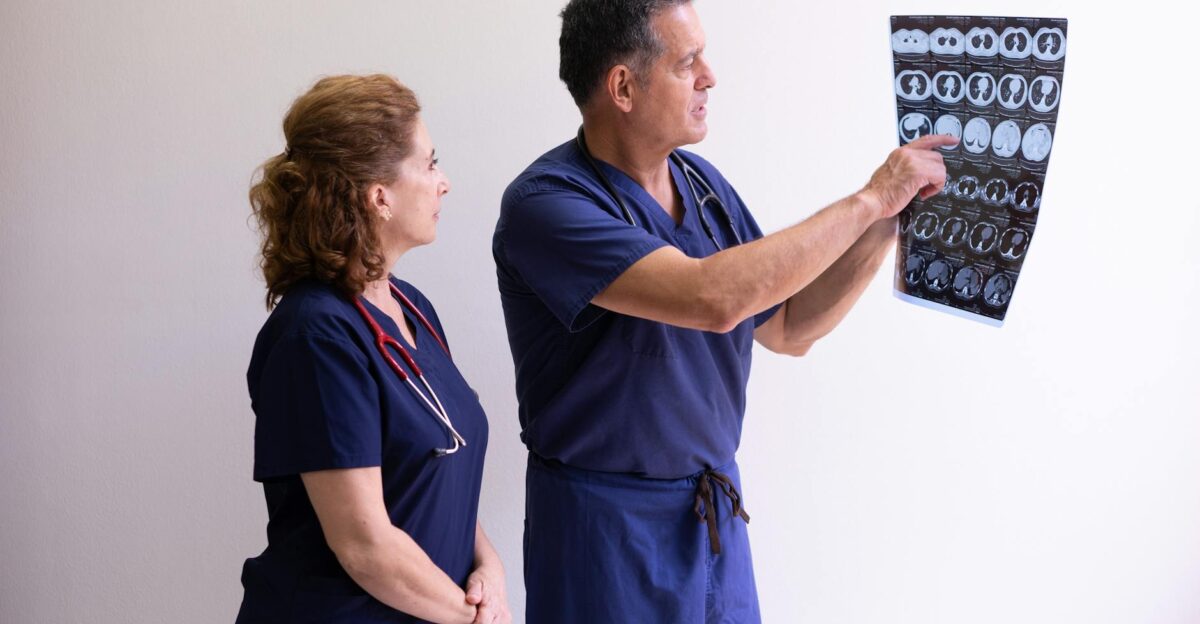 Two healthcare professionals in scrubs examining a medical x-ray image discussing diagnosis