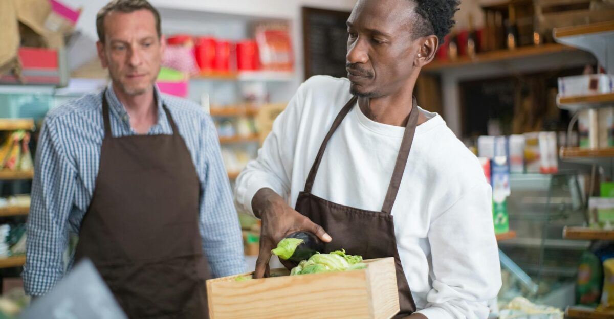 Men working in a grocery store arranging fresh vegetables and fruits Indoor setting focused on organic produce