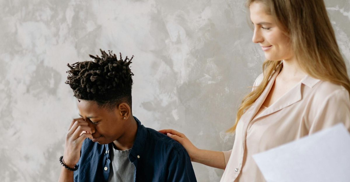 A boy appears frustrated during a piano lesson with a supportive teacher.