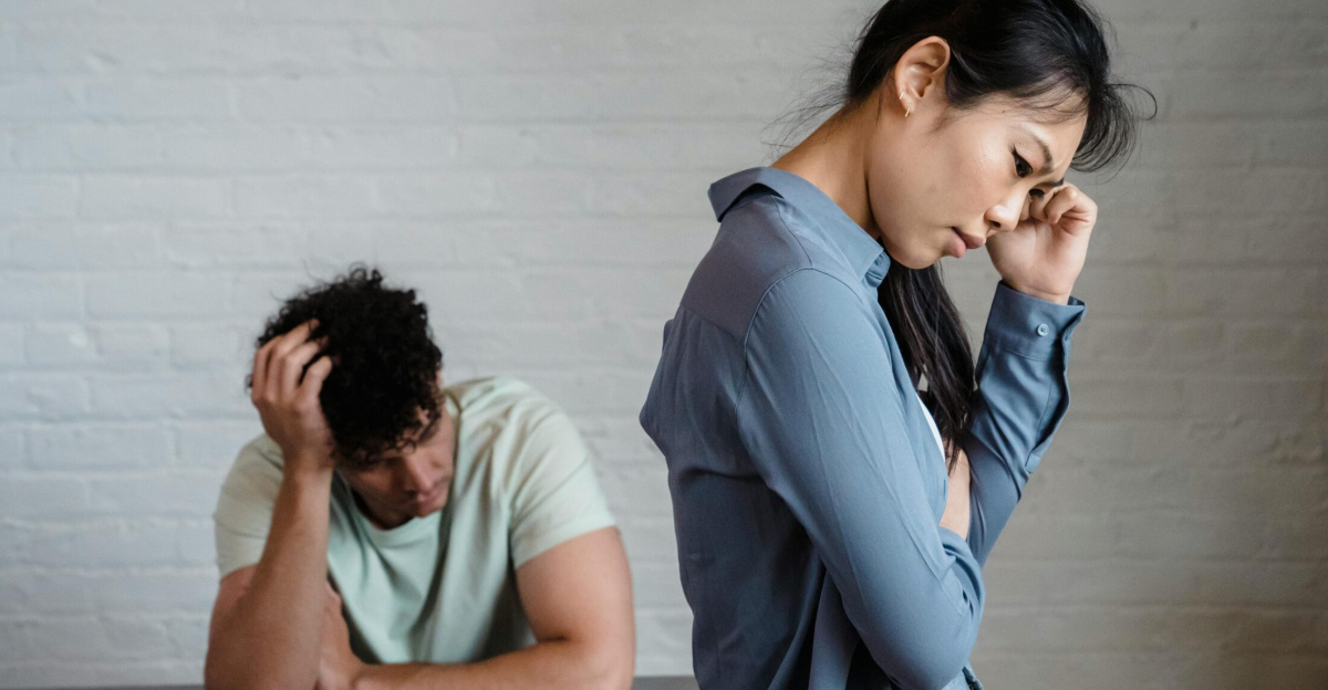 An Asian woman and man feeling misunderstood and frustrated in a relationship indoors.