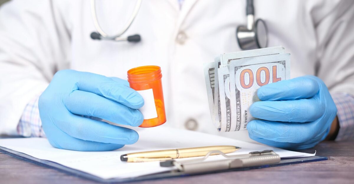 Doctor in gloves holding pill bottle and cash highlighting medical expenses