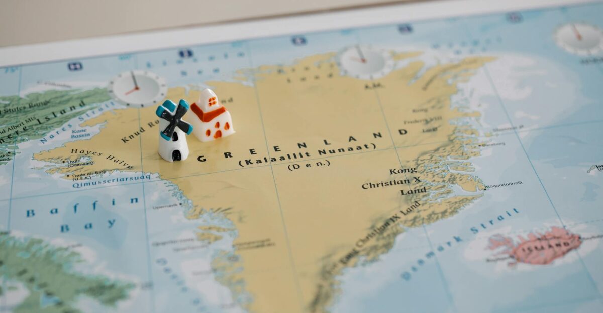 Toy houses on a detailed map of Greenland highlighting geographic features Ideal for travel concepts