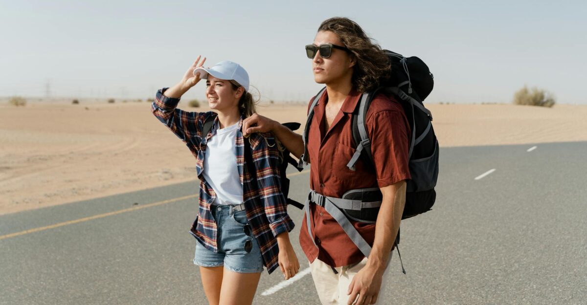 Young couple backpacking through a desert road capturing wanderlust and exploration