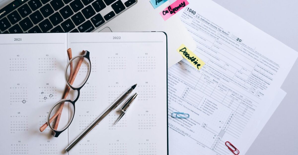 Organized workspace featuring a calendar tax documents and planner essentials