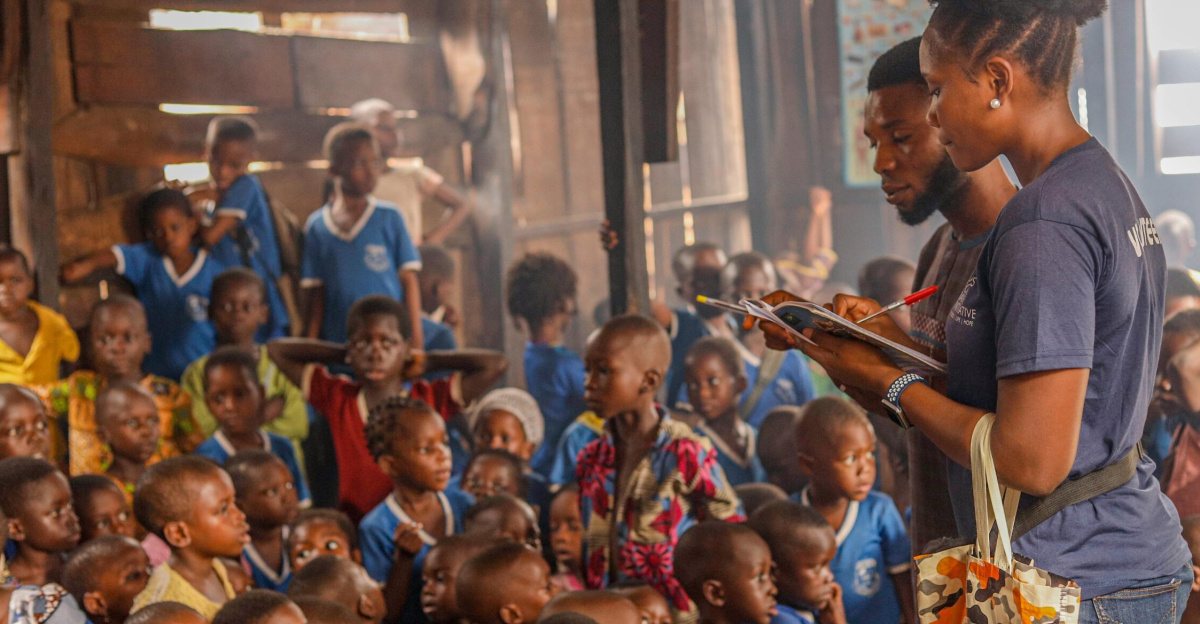Volunteers conduct an educational session for children in an indoor community space.