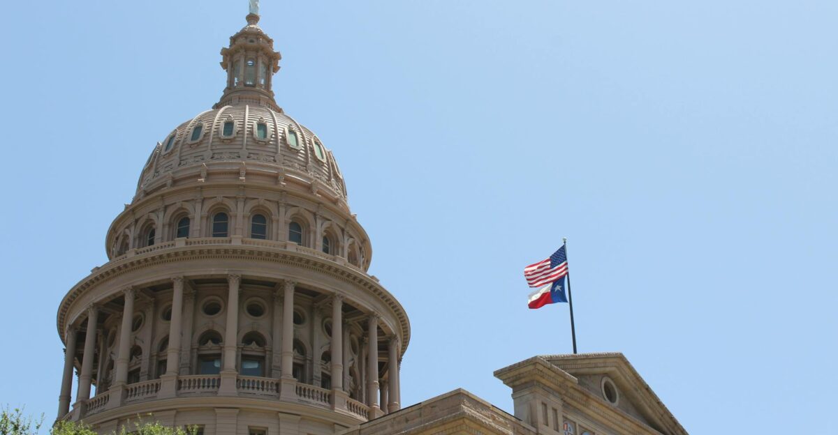 Low angle view of the Texas State Capitol dome and flags in Austin Texas