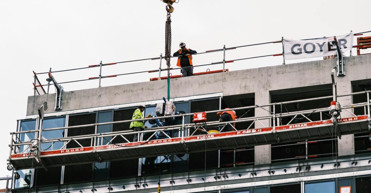 Professional workers at a construction site managing equipment on a high-rise building