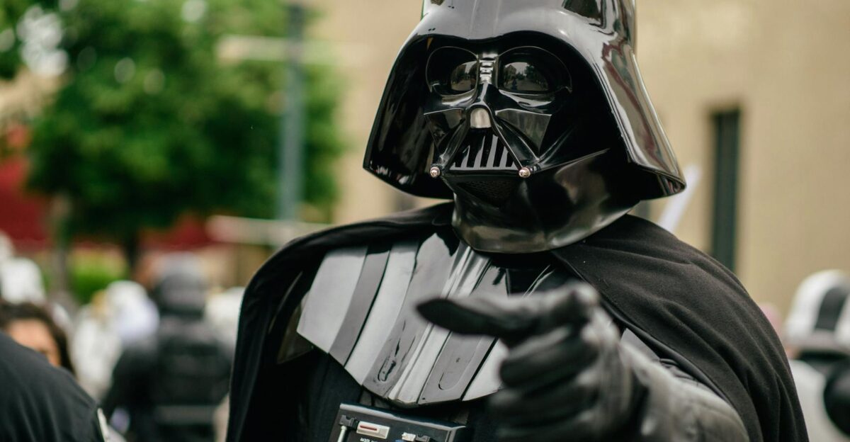 Darth Vader cosplayer pointing in an outdoor setting showcasing detailed costume and helmet