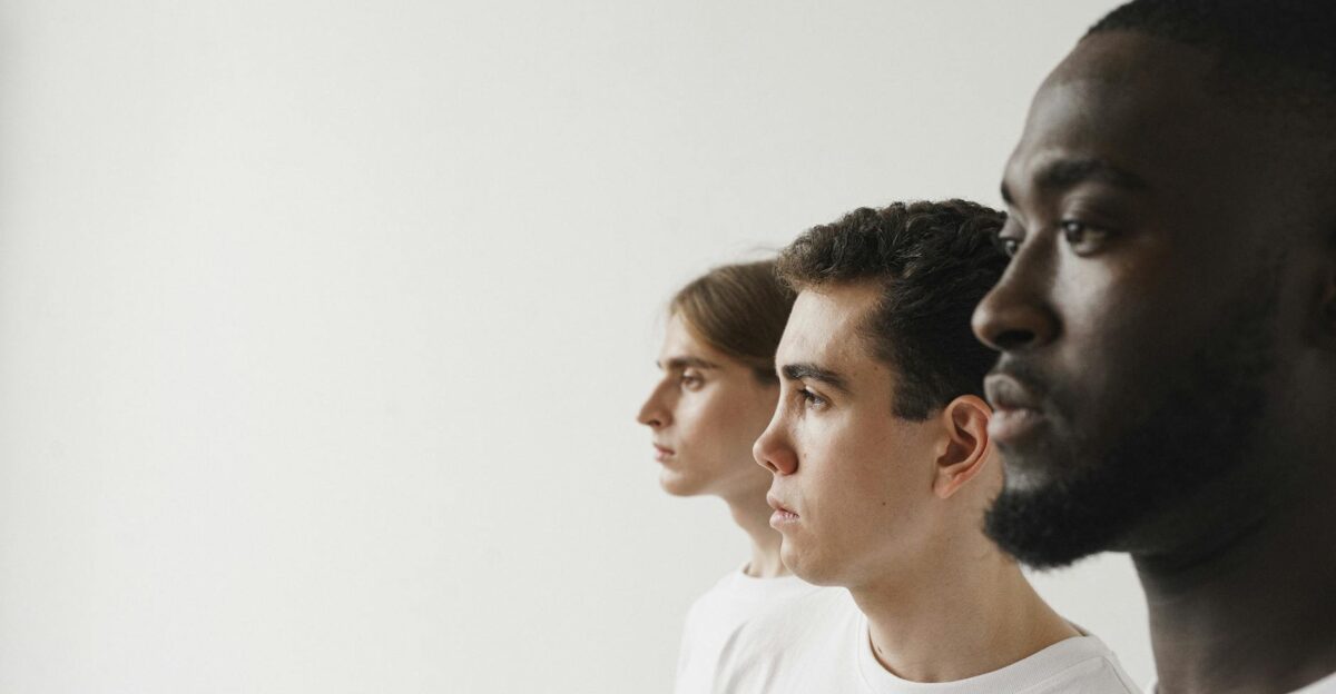 A diverse group of men in profile against a plain white background showcasing unity
