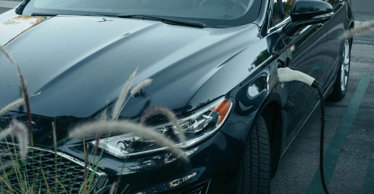 Close-up of an electric car charging at a station in a city parking lot showcasing clean energy technology