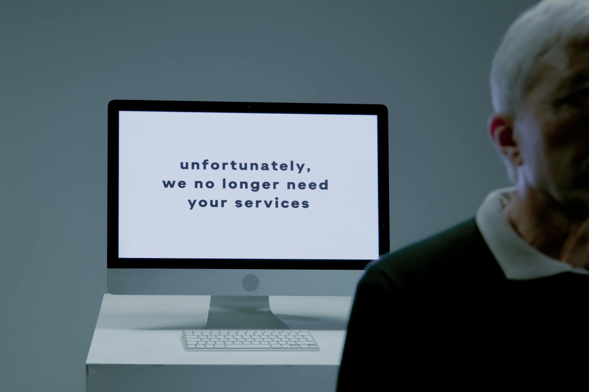 A computer screen displays a termination message indicating job loss or unemployment
