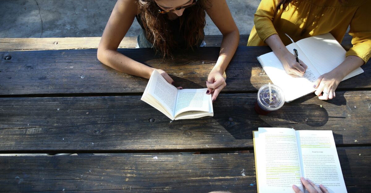 woman reading book while sitting on chair