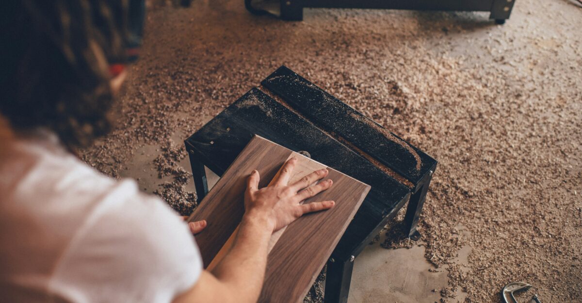 person touching brown plank