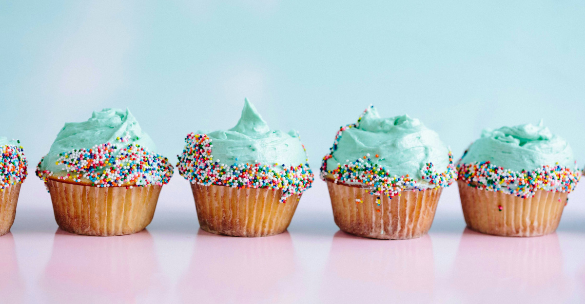 six teal icing cupcakes with sprinkles