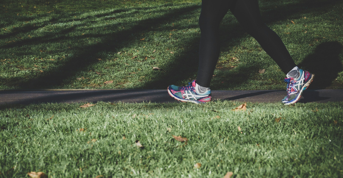 shallow focus photography of person walking on road between grass
