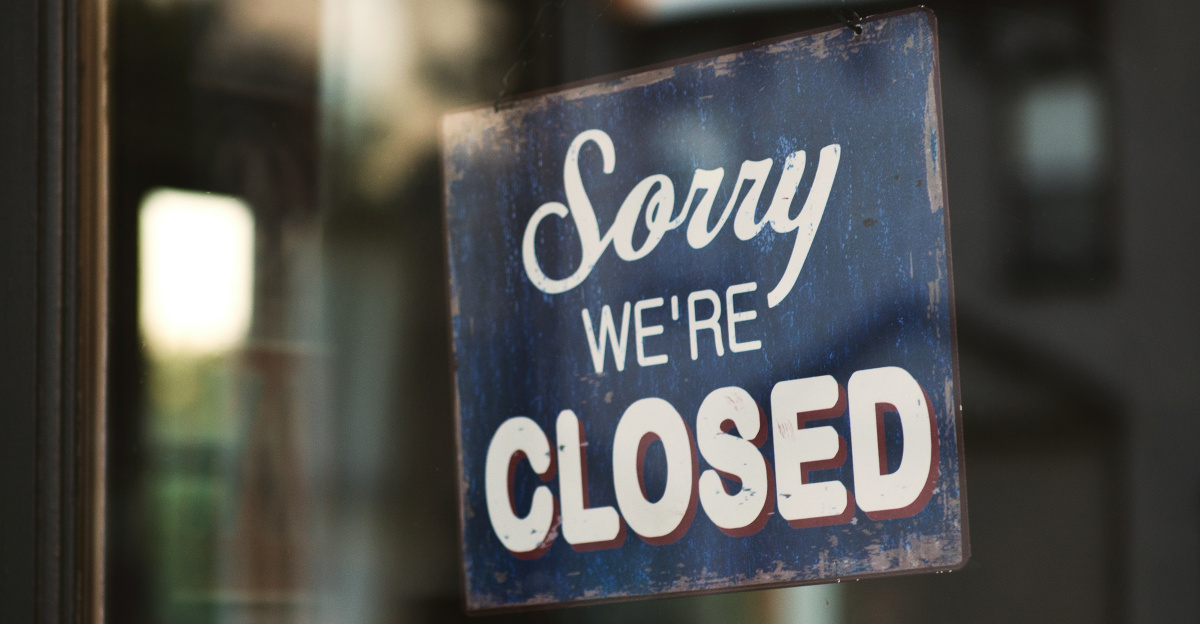 Sorry we're closed signage hanged on glass door