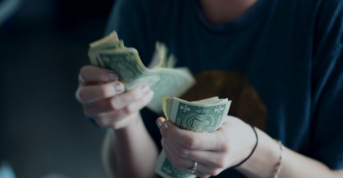focus photography of person counting dollar banknotes