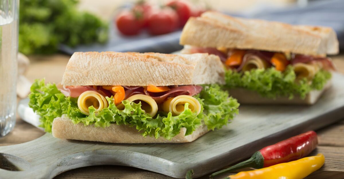 sandwich with lettuce and cheese served on chopping board