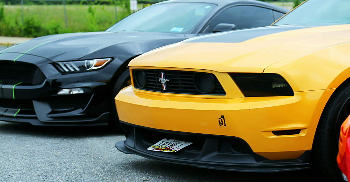 parked yellow Ford Mustang coupe and black