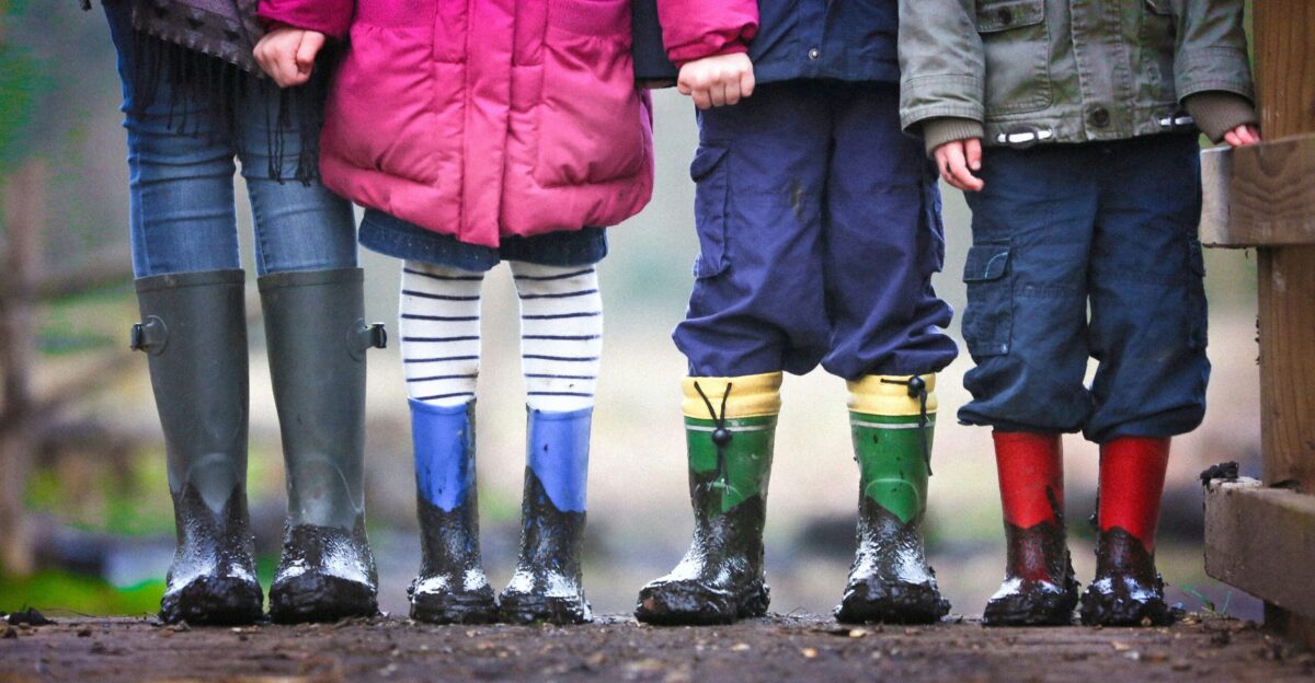 four children standing on dirt during daytime