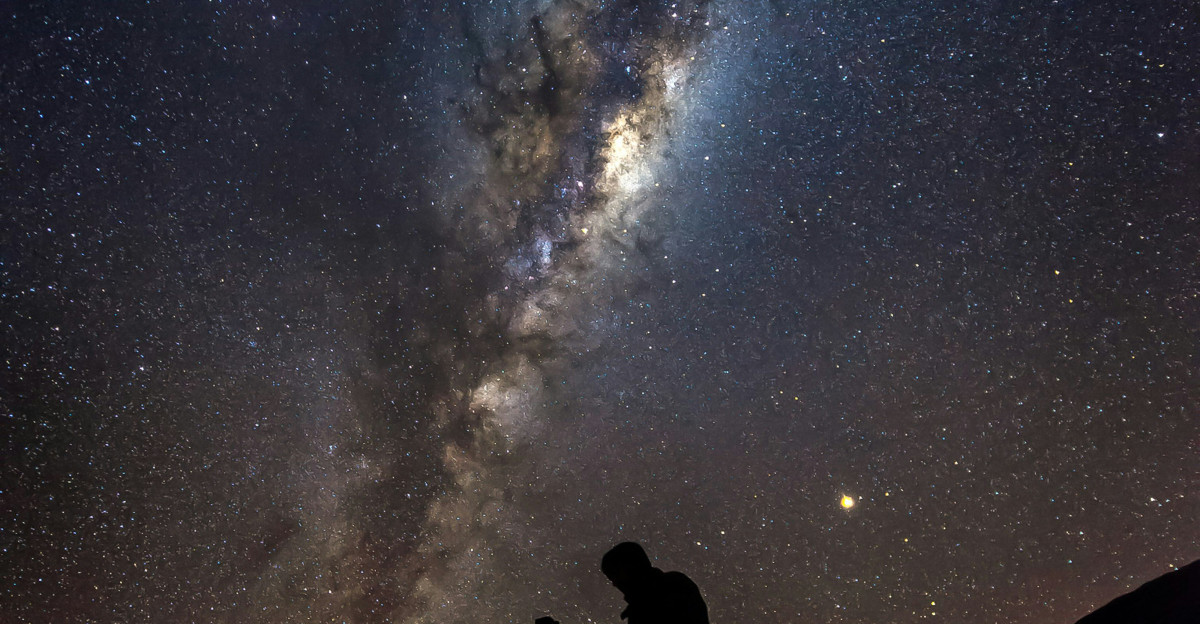 silhouette photo of man under Aurora phenomenon