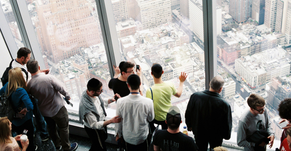 man wearing yellow shirt near the glass window