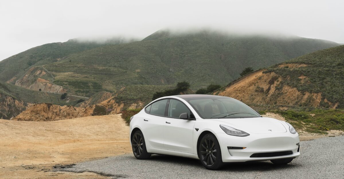 white sedan parked beside mountain during daytime