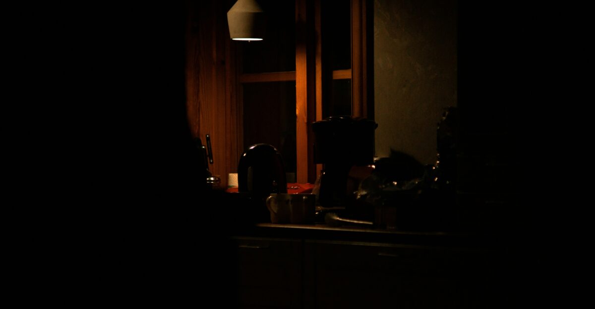 a dark room with a sink and a light