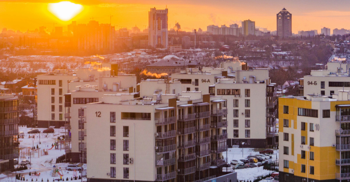 the sun is setting over a city with tall buildings