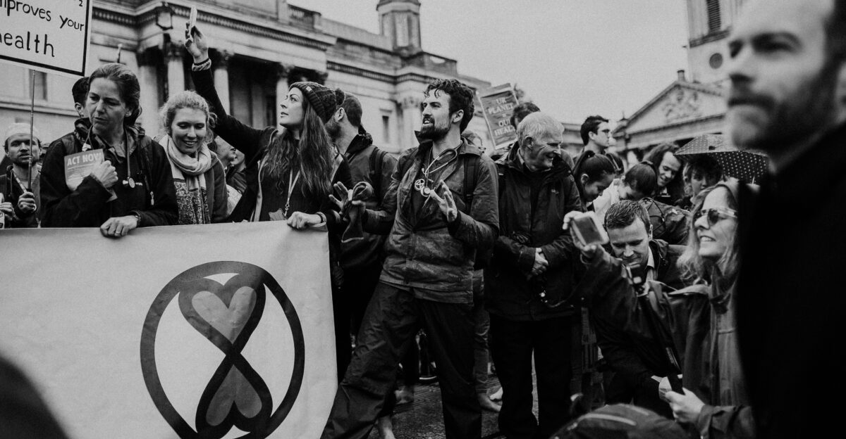 grayscale photography of men and women on a rally