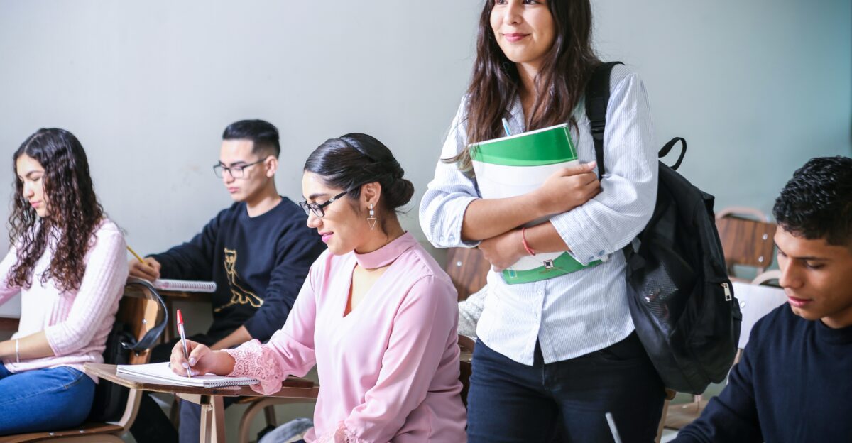 woman carrying white and green textbook