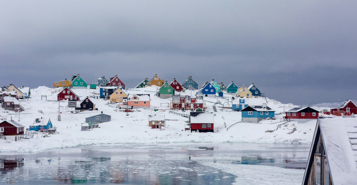 view photography of assorted-color houses near pond during daytime