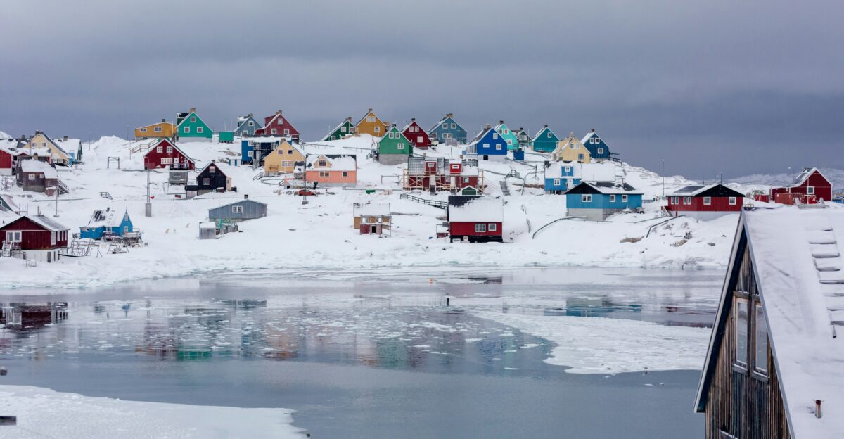 view photography of assorted-color houses near pond during daytime