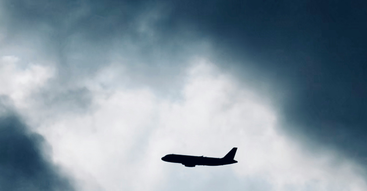 photo of flying black plane near clouds