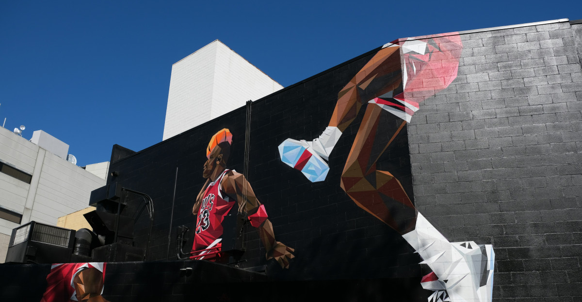 man in black jacket and pants sitting on black concrete wall during daytime