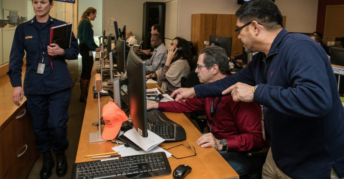 man in blue jacket using computer