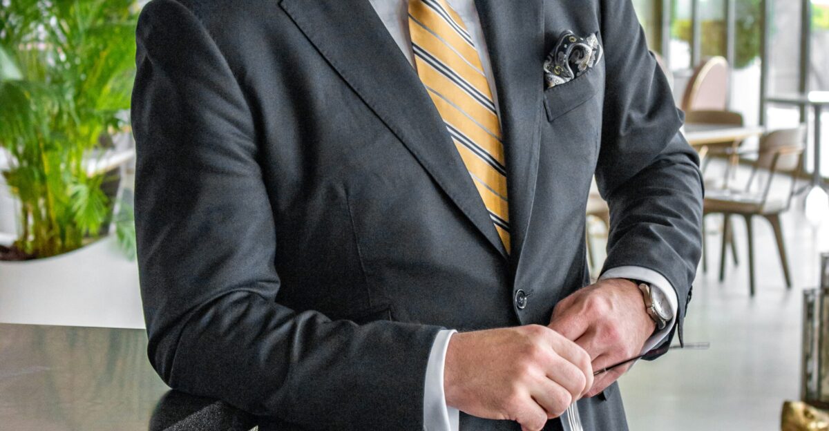a man in a suit is holding a tie