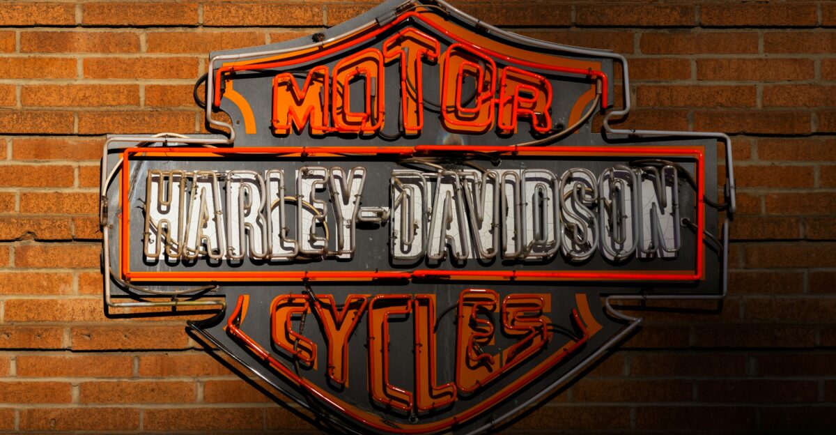 a harley davidson sign on a brick wall