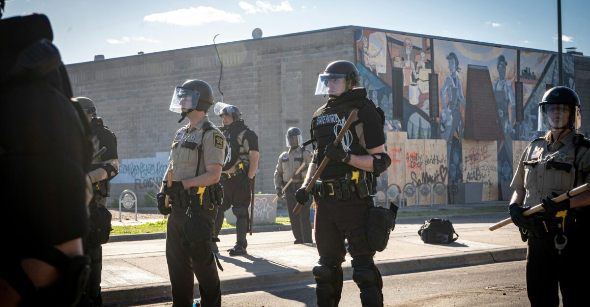 men in green and brown uniform standing on gray pavement during daytime