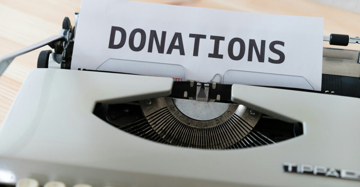 a close up of a typewriter with a donation sign on it