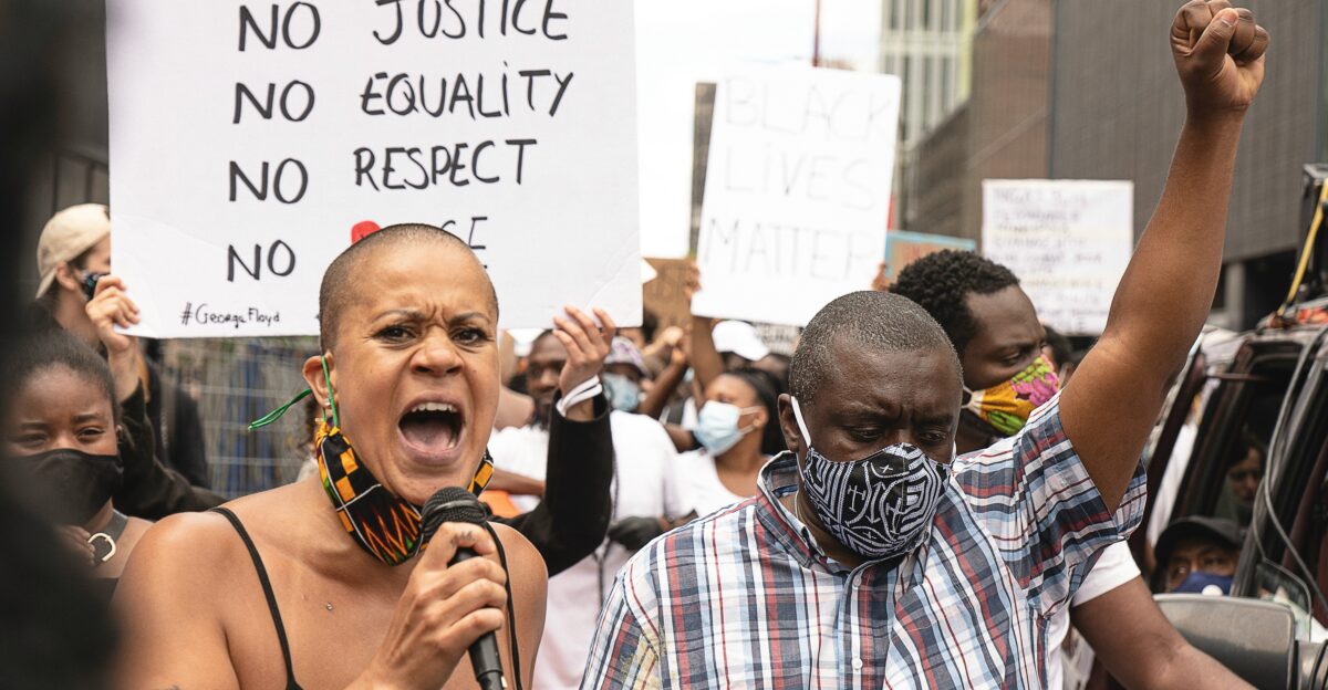 man in red white and blue plaid button up shirt holding microphone