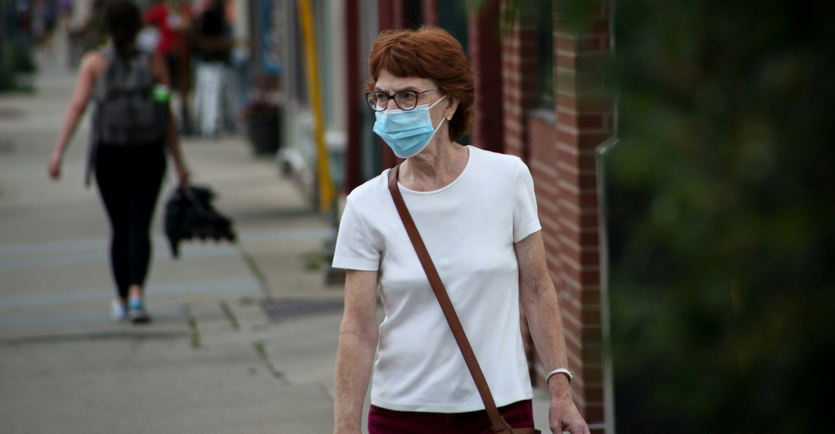 woman in white crew neck t-shirt and red pants standing on sidewalk during daytime