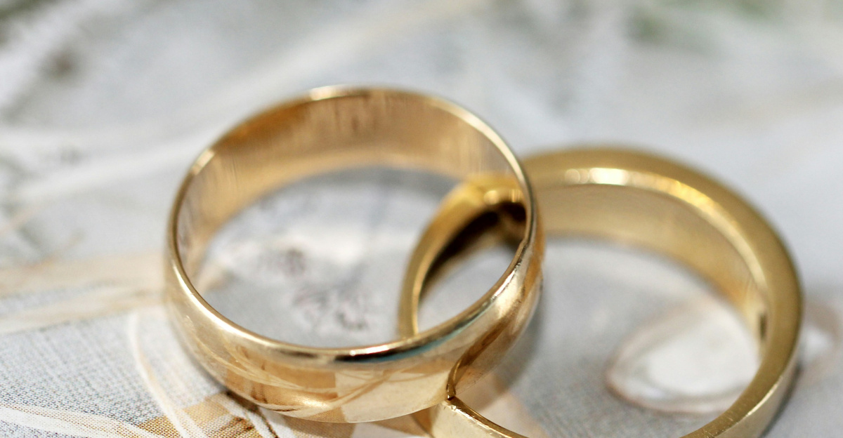 gold wedding band on white textile