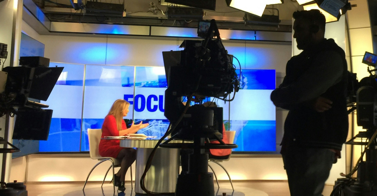 man in black suit standing on stage