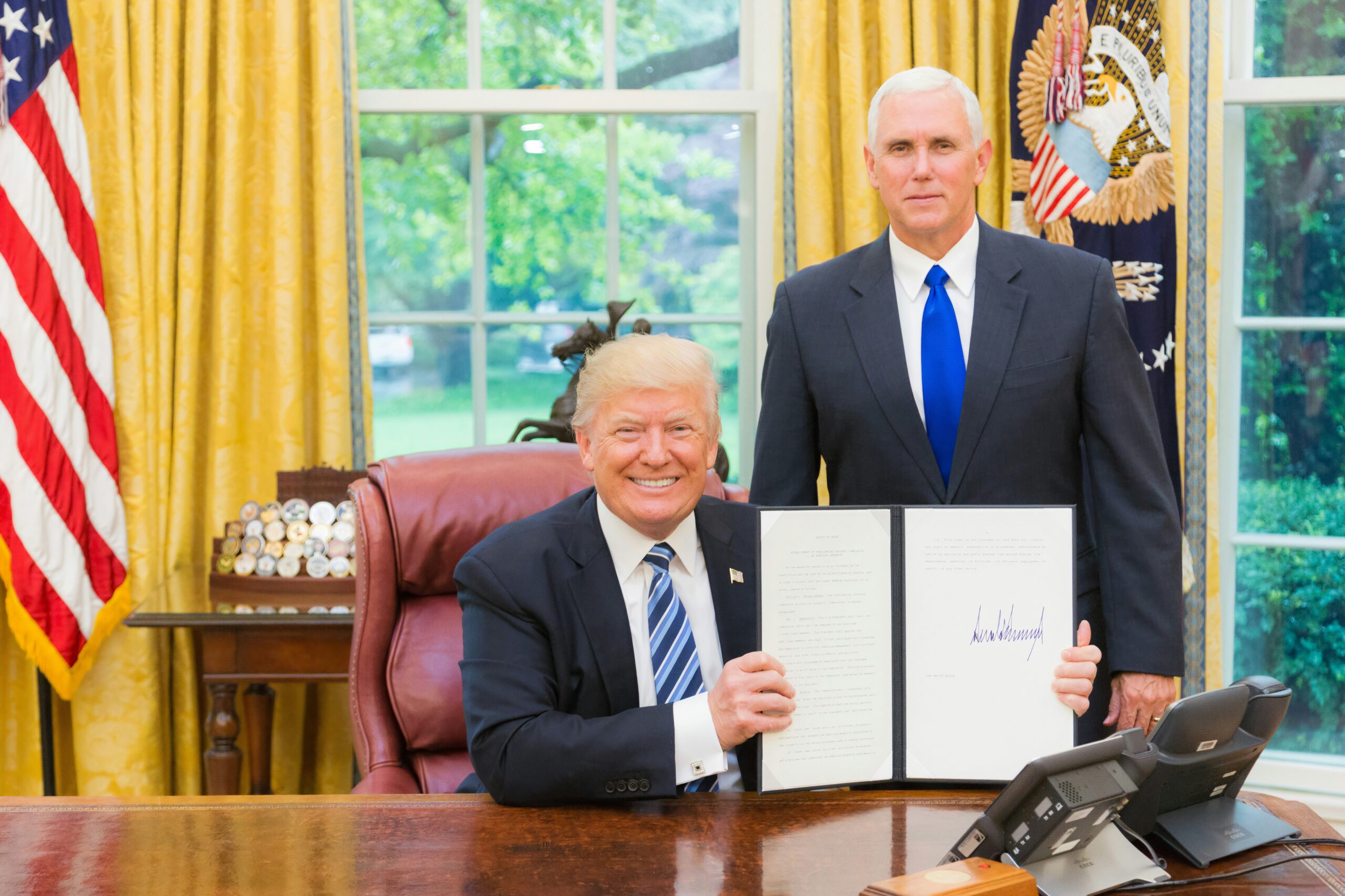 men in black suit sitting on red chair