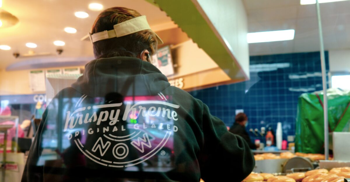 man in black and white hoodie standing in front of black and blue UNKs store